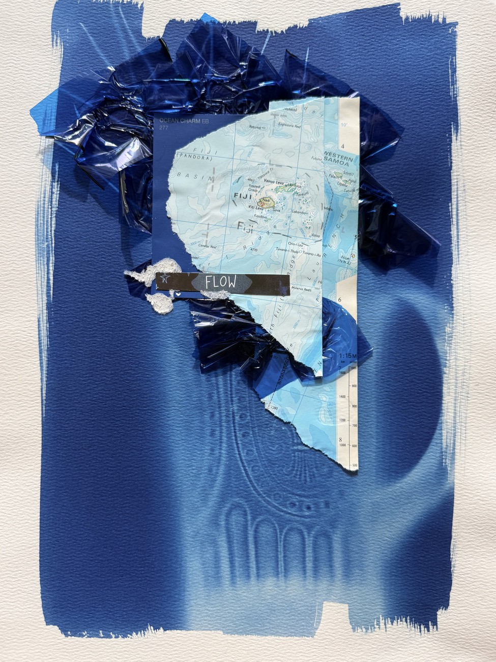A collage on white: a deep-blue painted ground with a torn map of Fiji and blue cellophane, and a small cut label reading FLOW